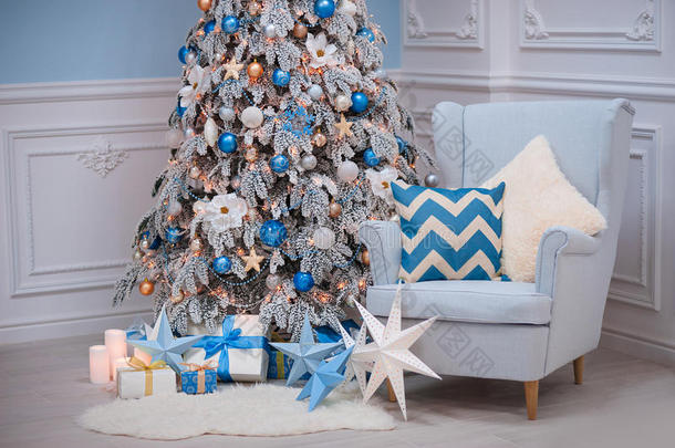 圣诞家居内部-一个舒适的扶手椅和装饰冷杉蓝色白色