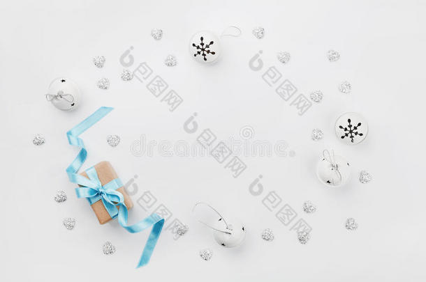 圣诞礼品盒，蓝色丝带和叮当铃在白色桌子上从上面。 节日贺卡。 模拟。 平躺框架。