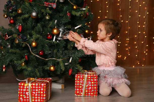 女孩在房子的内部装饰圣诞树