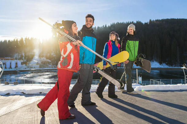 一群人滑雪和滑雪板度假村冬季雪山欢快快乐，微笑的朋友交谈度假