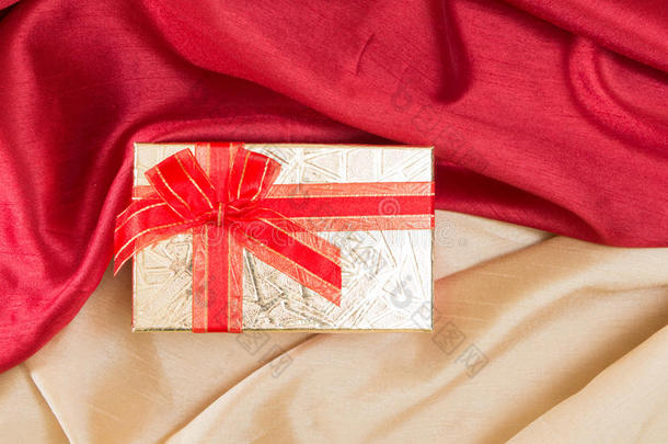 礼品盒与蝴蝶结，红色和金色波浪织物。