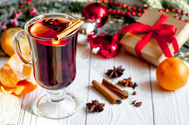 圣诞节在木制背景上用杯子里的香料覆盖葡萄酒