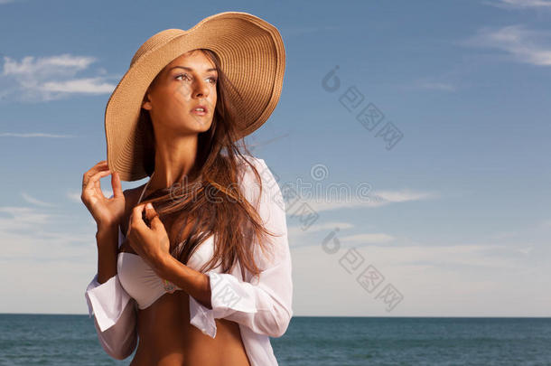迷人的女孩在海滩上享受炎热的夏日。