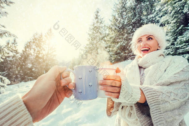 一对夫妇在冬天的森林草地上喝一杯热茶