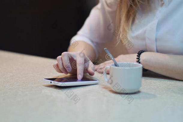 咖啡馆城市生活方式女人在电话里喝咖啡，在智能手机应用程序上发短信，坐在时尚城市的室内