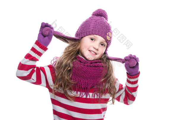 可爱的微笑小女孩戴着紫色针织围巾，戴着白色背景的帽子和手套。 冬天的衣服。