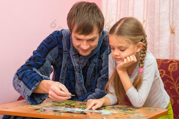 爸爸和女儿热情地收集拼图图片