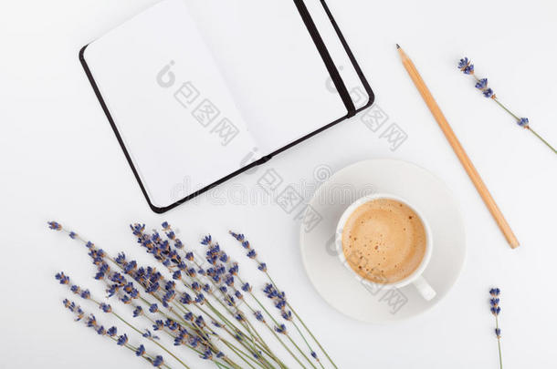 咖啡，干净的<strong>笔记本</strong>和薰衣草花白色背景从<strong>上面</strong>。 女人的办公桌。 舒适的早餐。 模拟。 平躺。