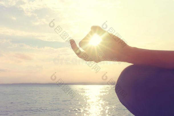 女人在海滩上冥想瑜伽姿势的手