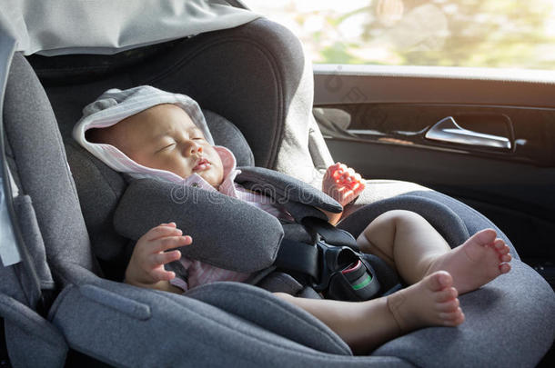 关闭亚洲可爱的新生婴儿睡在现代汽车座椅。