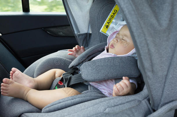 关闭亚洲可爱的新生婴儿睡在现代汽车座椅。