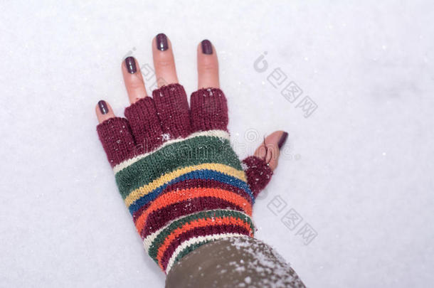 手拿冬天的手套，触摸覆盖着积雪的地面