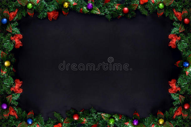 圣诞节或新年框架，树枝和彩色球在黑色背景与复制空间。