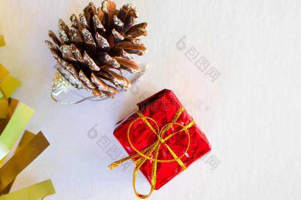 圣诞装饰品有金色五彩纸屑、红色礼物和松果筒。圣诞节或新年贺卡的垂直图像