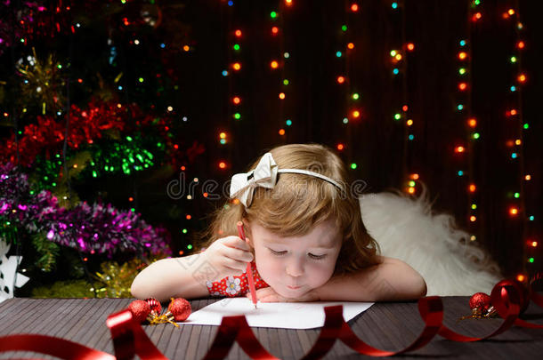 女孩用红色铅笔给圣诞老人写了一封信
