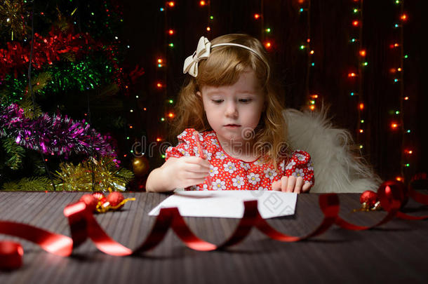 女孩用红色铅笔给圣诞老人写了一封信