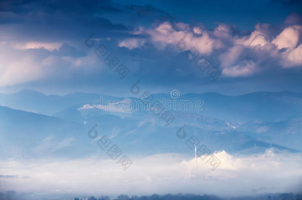 雾蒙蒙的阳光明媚的早晨在山上。 雾蒙蒙的山。 山谷镇。