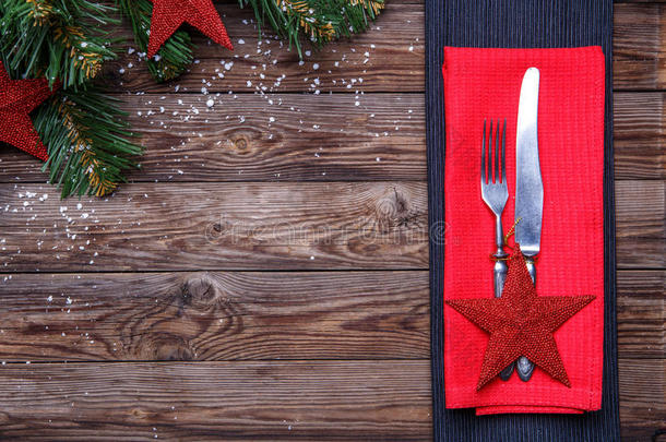 圣诞餐桌摆设有刀叉，装饰<strong>红星</strong>和红餐巾，圣诞松枝用