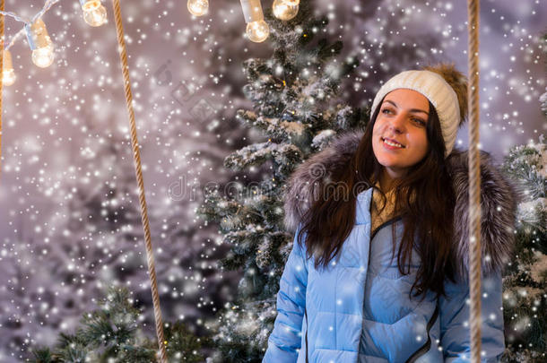 穿着蓝色羽绒服的可爱年轻女人站在雪地里