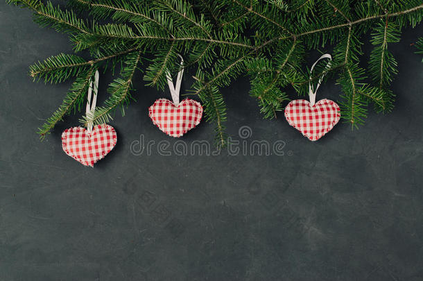 圣诞节黑暗的节日背景，自然装饰设置在一篇作文与手工制作的玩具红心，云杉树枝