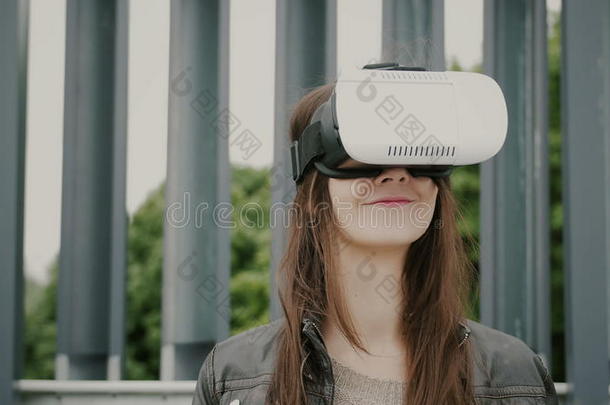 黑发女子女孩挥舞着头发，在城市空间使用虚拟现实眼镜。 4k