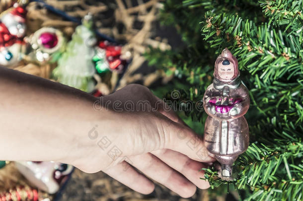把他的手挂在圣诞树上的圣诞树装饰品玩具上，以雪少女的形式出现
