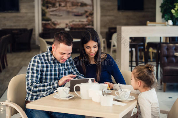 家庭，父母，科技人的概念-快乐的母亲，父亲和小女孩有平板电脑电脑