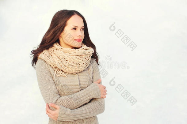 冬天穿针织毛衣和围巾的漂亮年轻女人