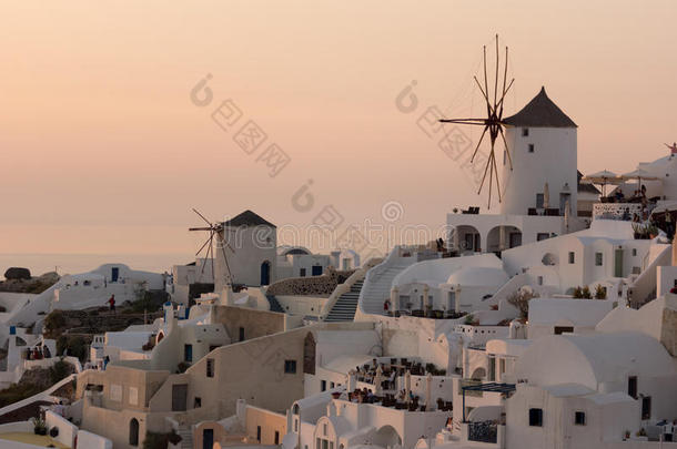 惊人的日落在白色风车在奥亚镇和全景桑托里尼岛，蒂拉，希腊