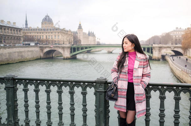 一个亚洲女孩独自站在桥上