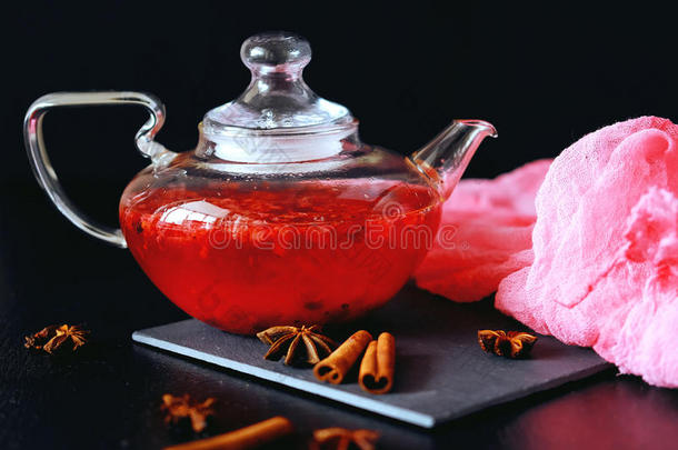 蔓越莓草药热茶饮料在玻璃茶壶与肉桂和