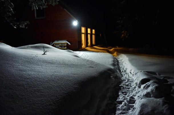 小屋的烟囱灯照亮了冬天外面的雪