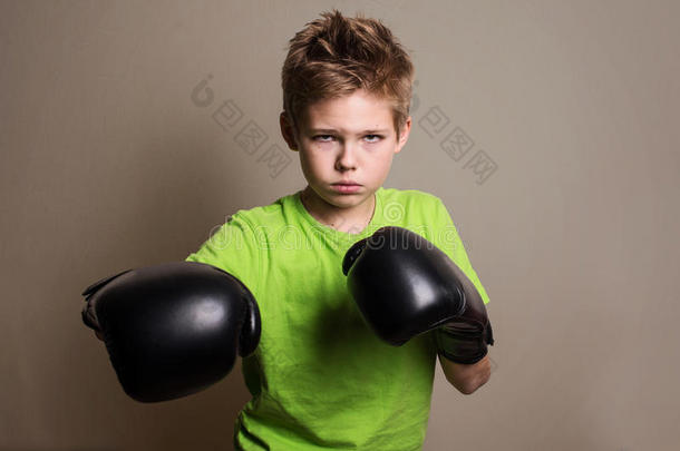 关闭拳击手男孩戴着手手套，看着凶猛的