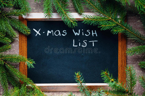 黑板周围是冷杉树枝，上面有文字圣诞<strong>愿望清单</strong>