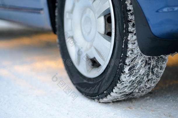 雪道上冬季汽车轮胎的特写图像。 开车安全。