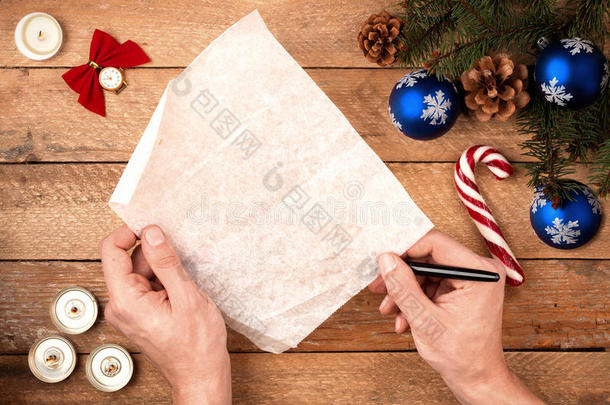 圣诞背景男子`手拿着一支钢笔，拿着一封信