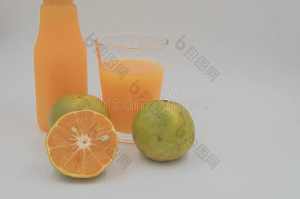 新鲜的橙色水果和果汁在一个瓶子和玻璃的白色背景。