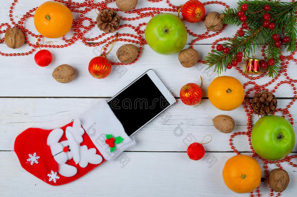 圣诞节装饰和袜子与智能手机在一个木制的巴