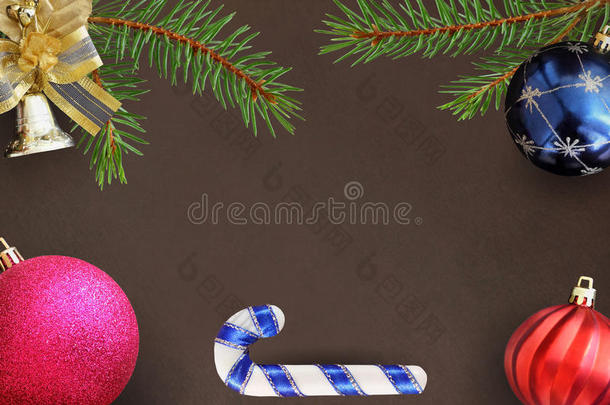 圣诞树枝云杉，棍子，蓝色，粉红色和红色气球，装饰钟在黑暗的背景