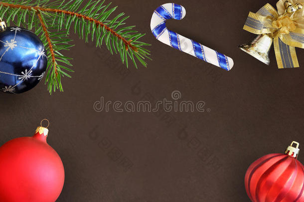 圣诞冷杉树枝，棍子，蓝色和红色波浪气球和装饰钟在黑暗的背景