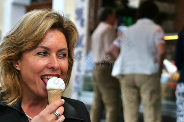 有吸引力的女人在意大利冰淇淋店前吃冰淇淋，冰淇淋