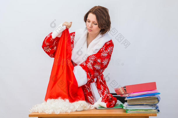女孩办公室的工作人员打扮成圣诞老人，从包里拿出一些东西在桌子上送礼物