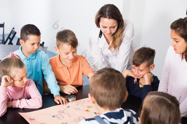 小学年龄感兴趣的孩子在桌子上玩棋盘游戏和