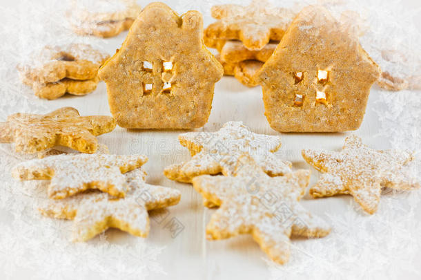 圣诞姜饼屋，白色木材背景上的星星和林泽饼干，烛光，糖霜冰花纹理小插画