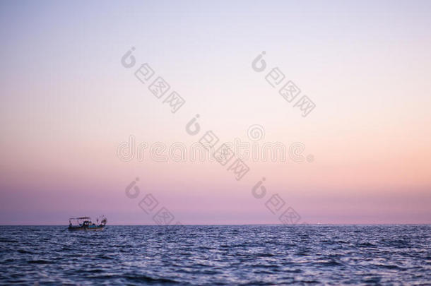 渔船日落海。 日落时漂浮在海里的渔船渔民。 渔民收集他们的网。 商船的轮廓