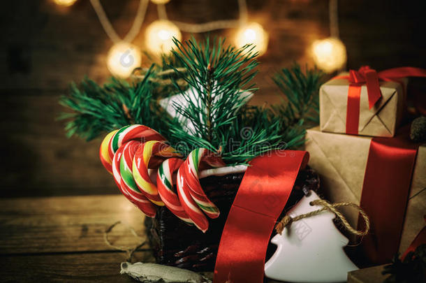 圣诞礼物与盒子，针叶树，篮子，糖果甘蔗锥在木制背景。 复古风格。
