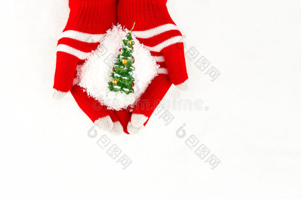 圣诞卡，手套在手上拿着圣诞树和雪