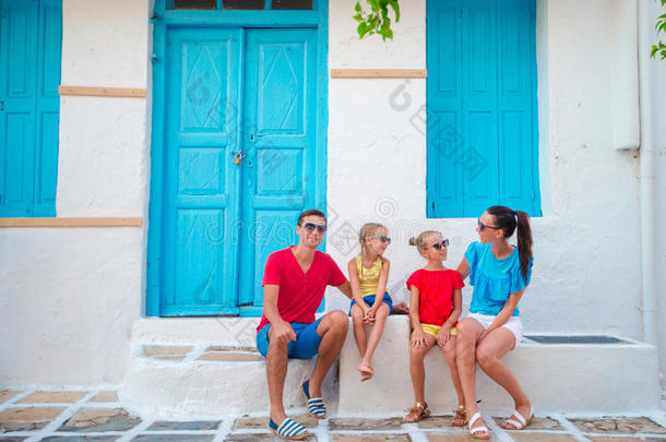 家庭在麦科诺斯暑假。 传统希腊村庄狭窄街道的父母和孩子