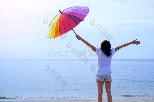 在海里的卷曲女孩。 带着雨伞的年轻女人
