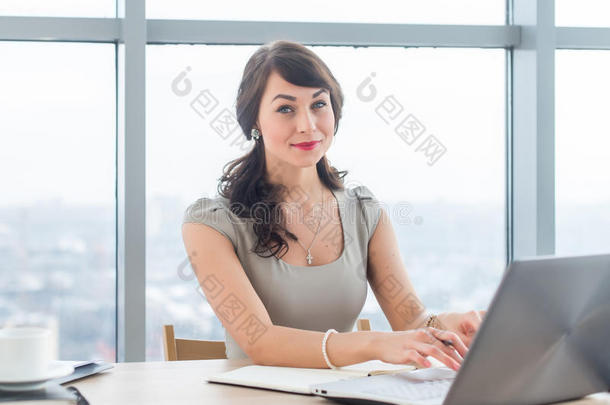 漂亮的女<strong>文案</strong>坐在办公室里，打字，用文字<strong>工作</strong>，在<strong>工作</strong>场所使用笔记本电脑。